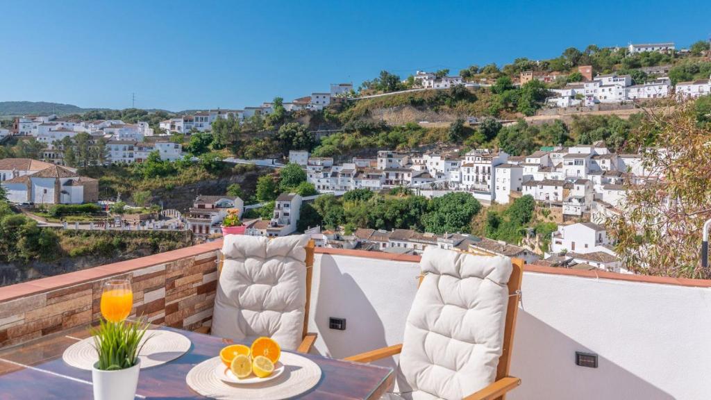 a balcony with a table and chairs with a view at Los Cortinales Setenil de las Bodegas by Ruralidays in Setenil