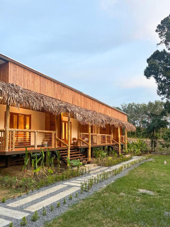 a large building with a grass roof at Painon Resort KohLanta in Ko Bu Bu