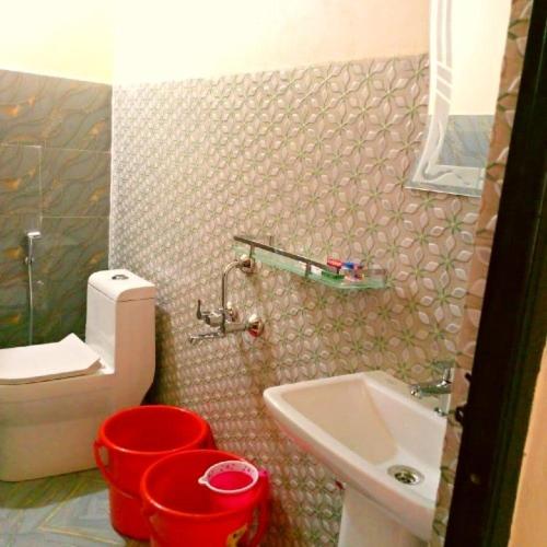 Pari's Homestay and Food Centre في Mawlynnong: حمام مع مرحاض أبيض ومغسلة