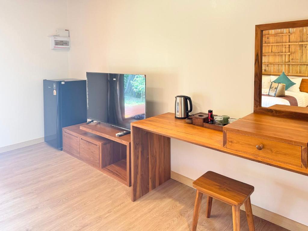 Cette chambre dispose d'un bureau, d'une télévision et d'un miroir. dans l'établissement Painon Resort KohLanta, à Ko Bu Bu