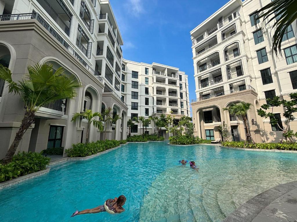 邦涛海滩Condo 1 BR at The Title Legendary near Bangtao Beach的两人在大楼的游泳池游泳