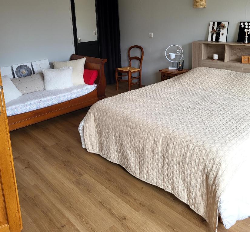 a bedroom with a bed and a chair at A la terrasse du val de vincelles in Nanteuil-lès-Meaux