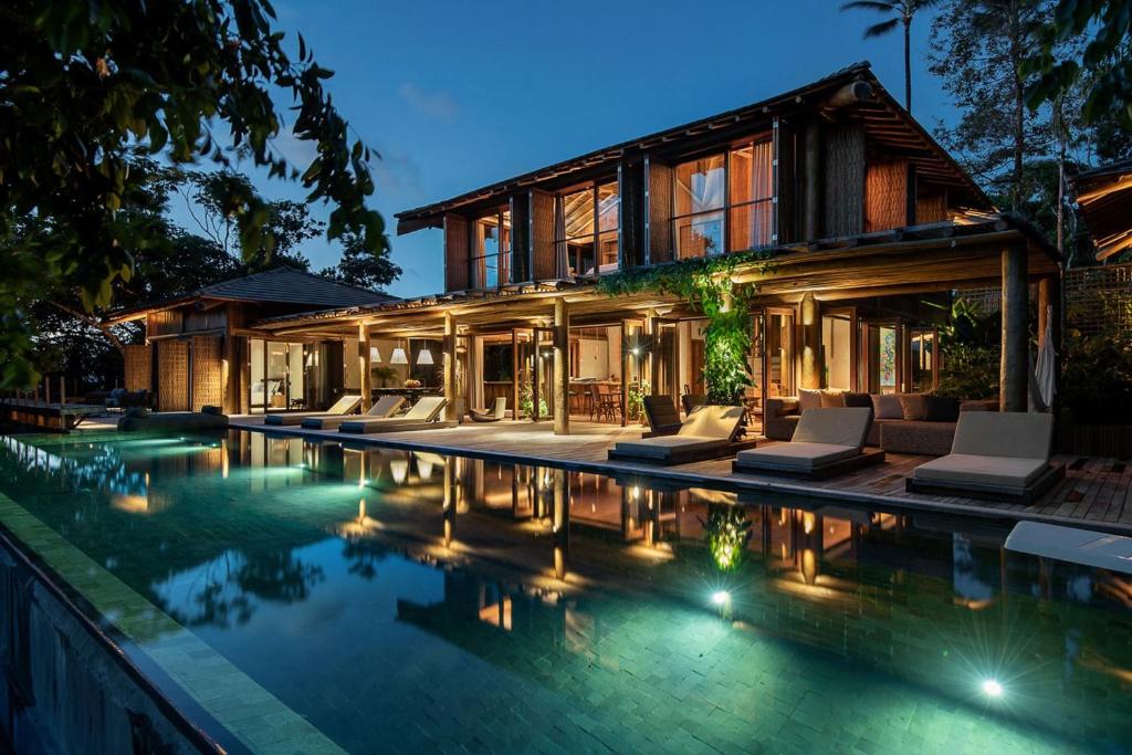 a villa with a swimming pool at night at Villa 21 in Itacaré