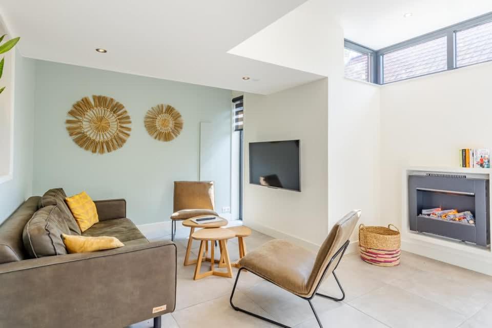 ein Wohnzimmer mit Sofa und Kamin in der Unterkunft Hello Zeeland - Vroonweg 34 in Oostkapelle
