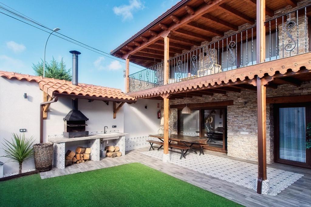 an outdoor patio with a fireplace and a deck at Casa con encanto Lemus in Celada