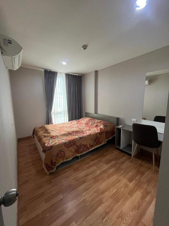 een slaapkamer met een bed, een bureau en een raam bij AC Home 1 Laksi in Lak Si