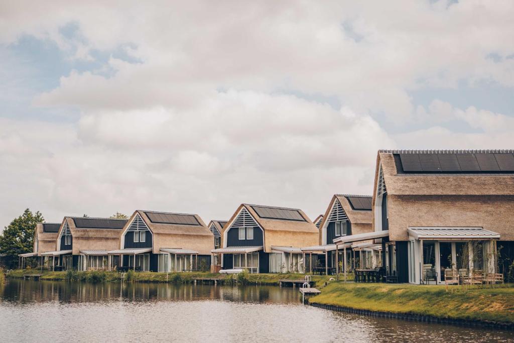 una fila di case vicino a un corpo d'acqua di Watervilla buitenzijde | 6 personen a Heeg