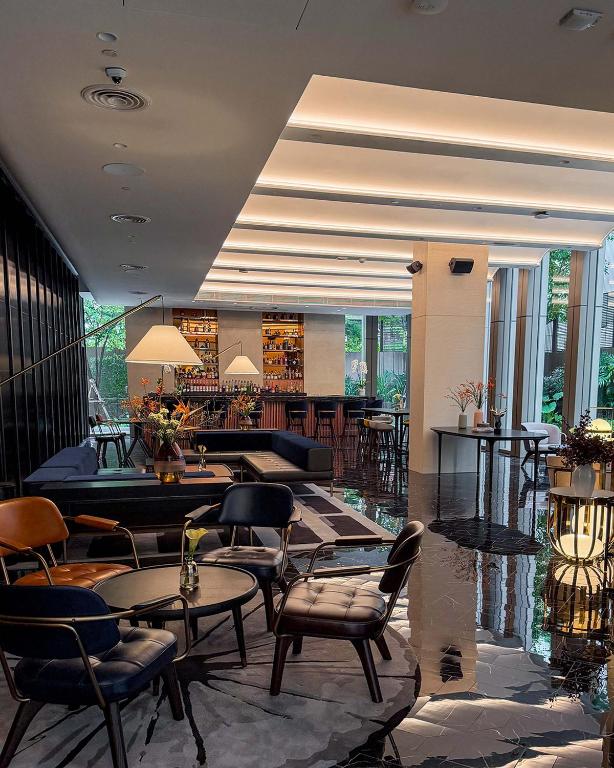 A bright lounge lobby with mixed seating and a visible bar.