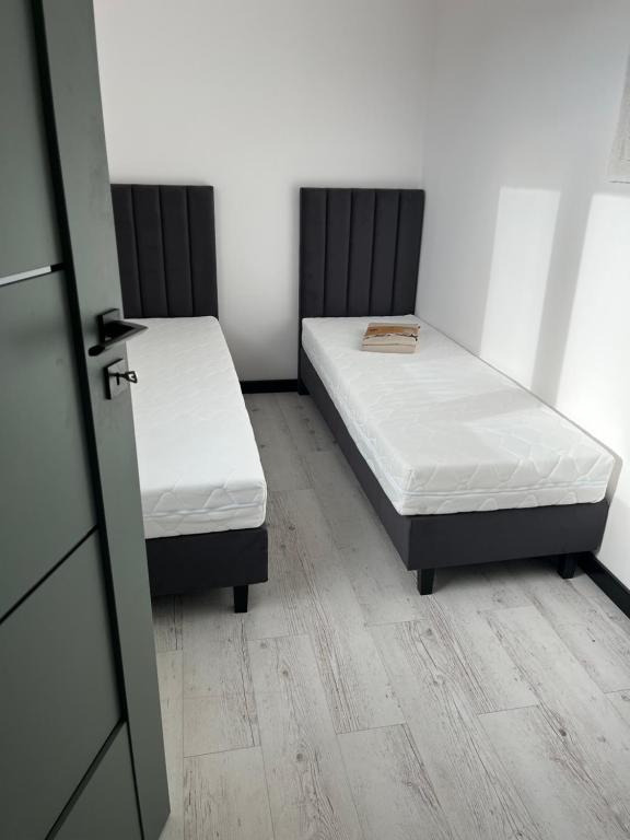 Wiejska Przystań Bory Tucholskie的带门的房间,设有两张单人床