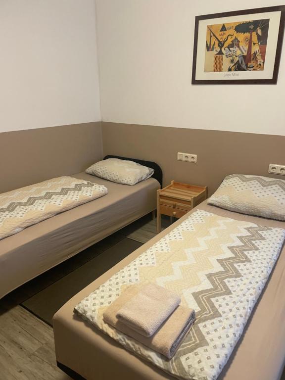two beds in a small room with towels on them at LIVI Hostel und Pension in Dortmund