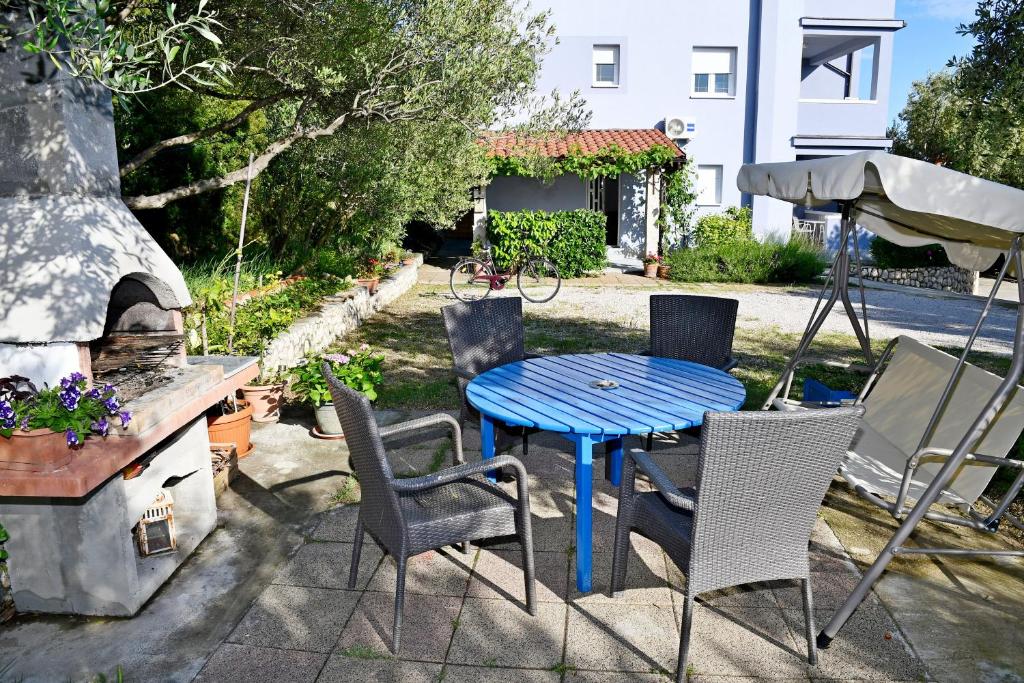 a blue table and chairs on a patio at apartmani Novotny crveni in Banjol