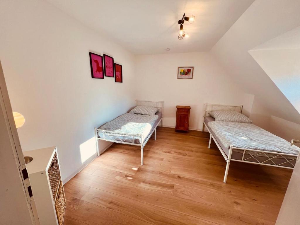 two beds in a room with wooden floors at Fewo Geib in Meisenheim