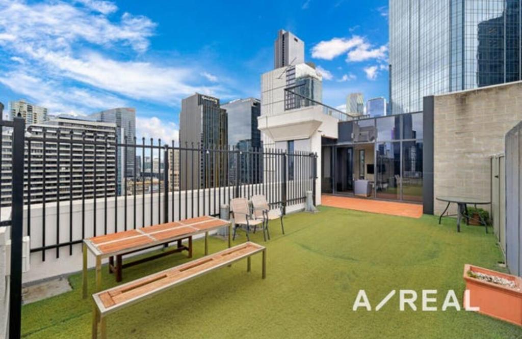 un patio all'ultimo piano con panchine e vista sulla città di Central Melbourne 2BR Balcony Apartment a Melbourne