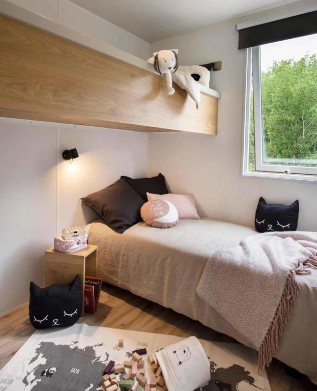 une petite chambre avec un lit et une fenêtre dans l'établissement Camping 4 étoiles - Piscine - ccaaeah, à La Baule 118 autres photos