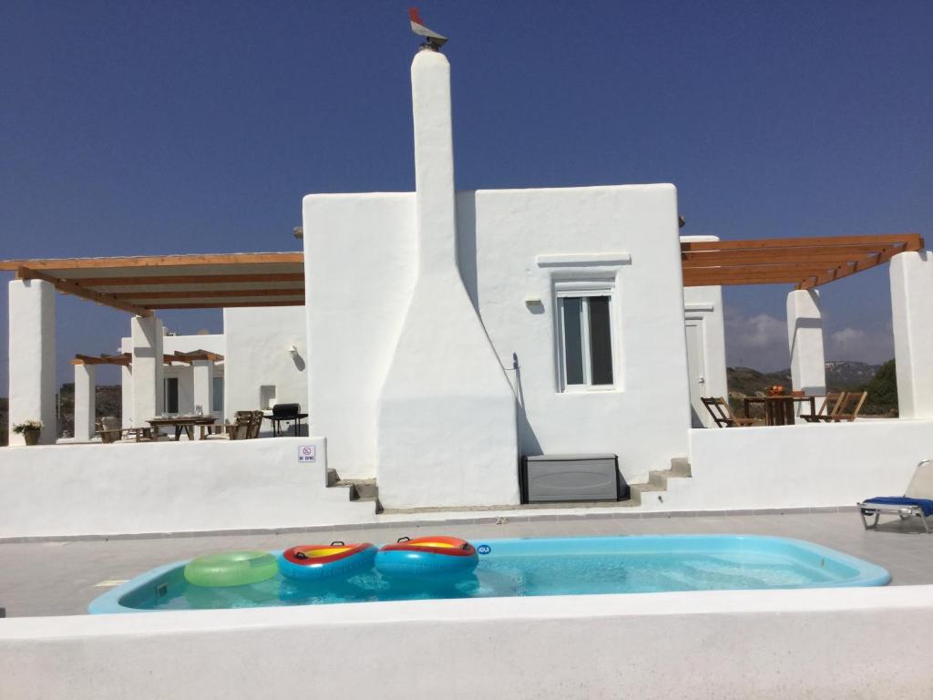 a swimming pool in front of a house at Sea Breeze in Lachania