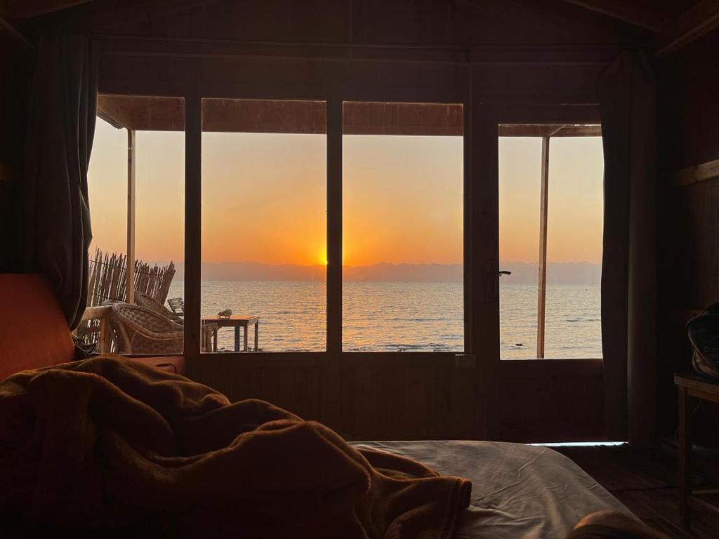 une chambre avec une fenêtre donnant sur l'océan dans l'établissement Sea View Camp Nuweiba, à Wāsiţ