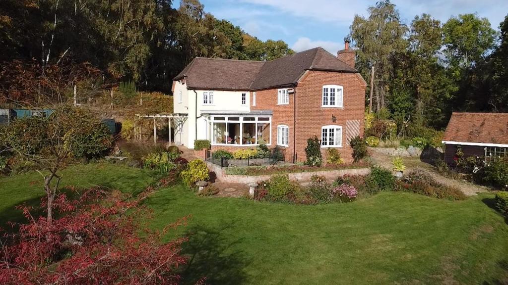 a large brick house with a yard at 3-bedroom cottage set in a large enclosed garden in Thatcham