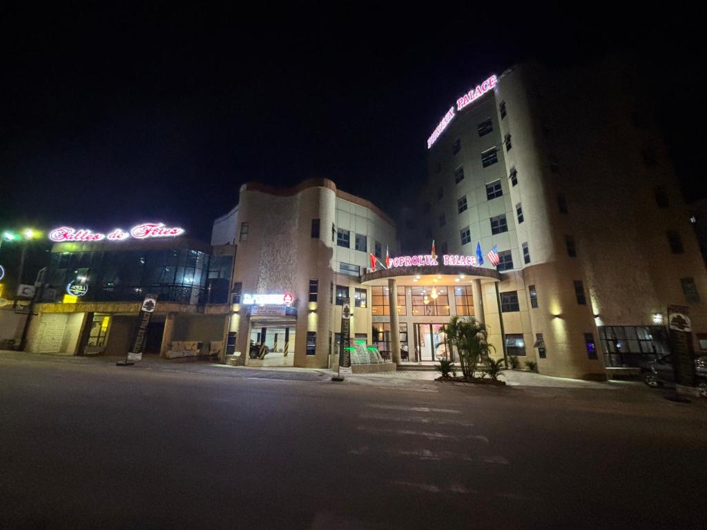 Un edificio con un cartel encima por la noche. en FOPROLUX PALACE hôtel, en Douala