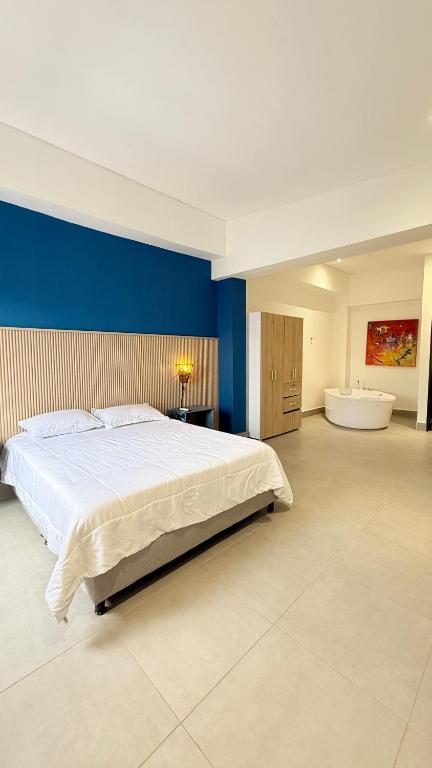 a large bedroom with a large bed and a tub at Hotel Gallery Boutique in Pereira