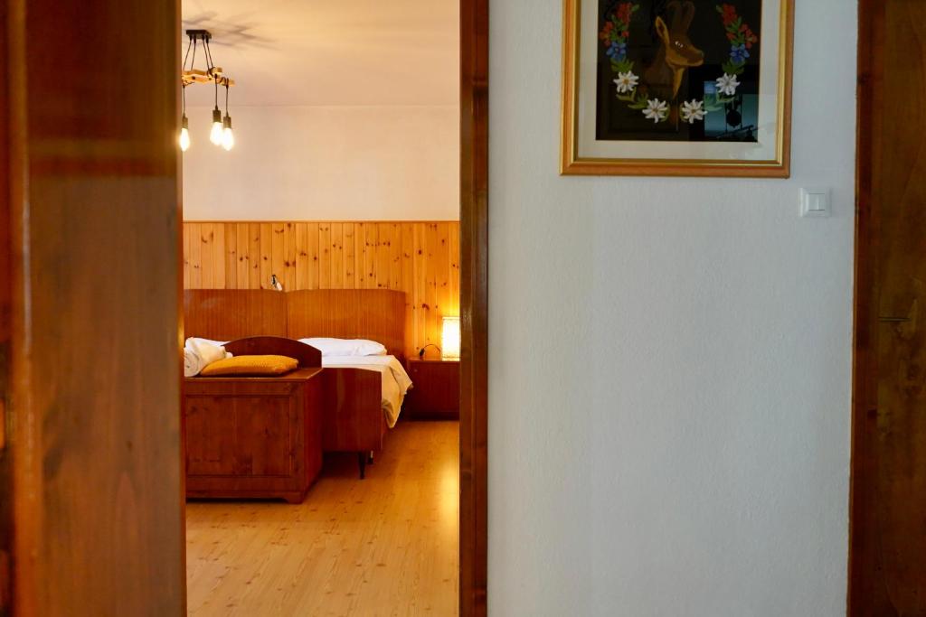 un corridoio che conduce a una camera da letto con un letto di Casa vacanze Danoi Dolomiti a Canale dʼAgordo