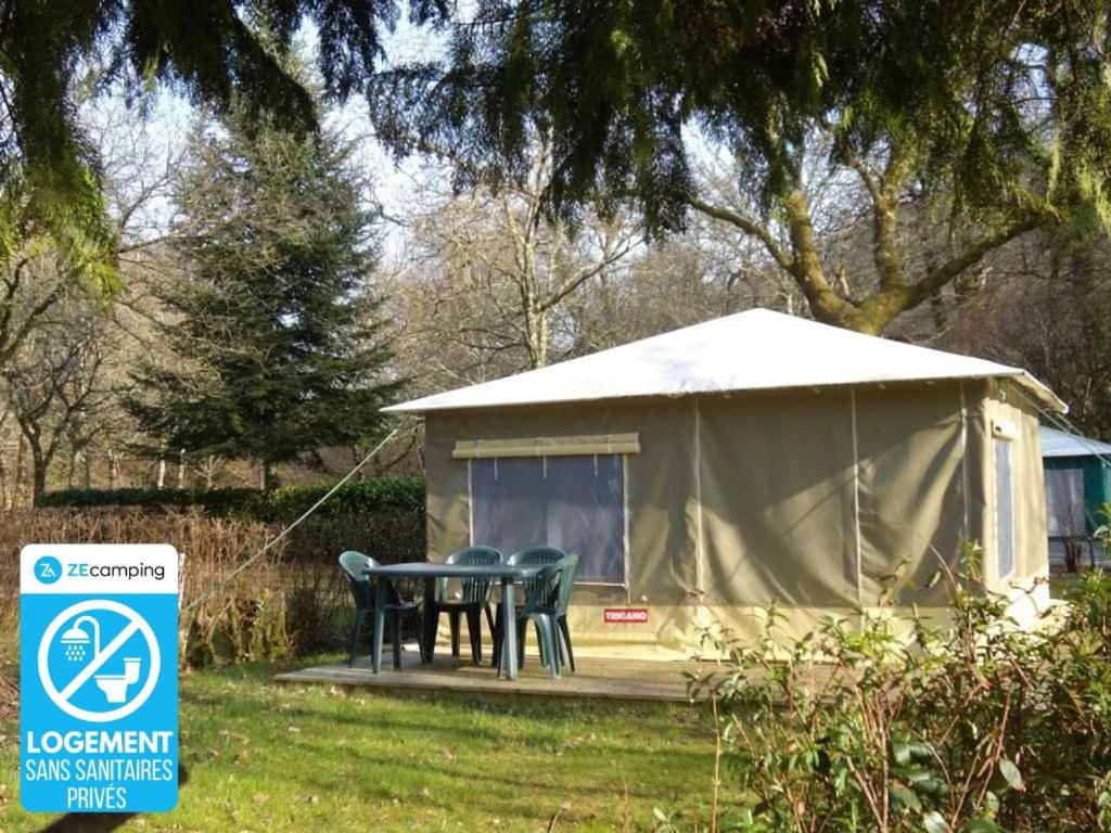 une tente avec une table et des chaises dans une cour dans l'établissement Camping 3 étoiles - Piscine - ccafbbc, à Huelgoat