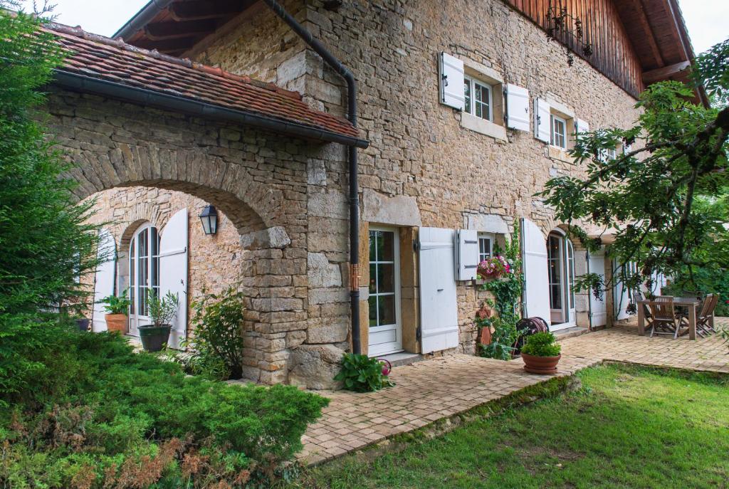 een stenen huis met een boog in een tuin bij Domaine des Rochaules 