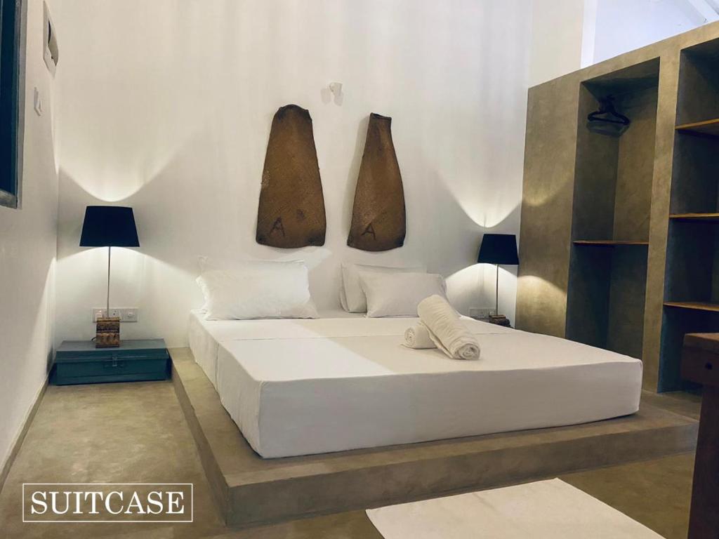 Suitcase في أمبالانغودا: غرفة نوم مع سرير و مزهرين على الحائط