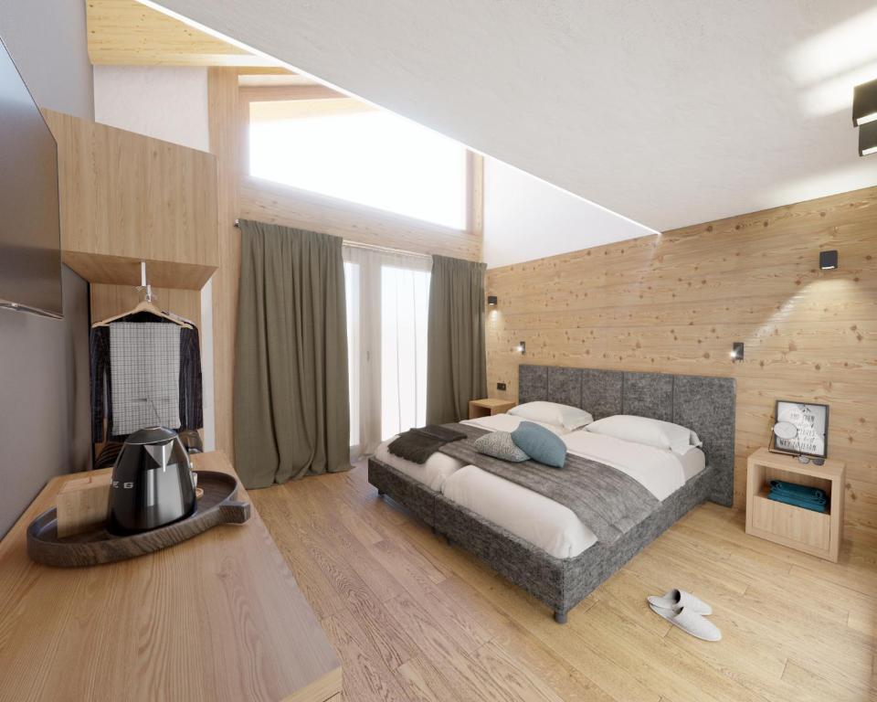 a bedroom with a large bed and a television at Hotel Astoria in Livigno