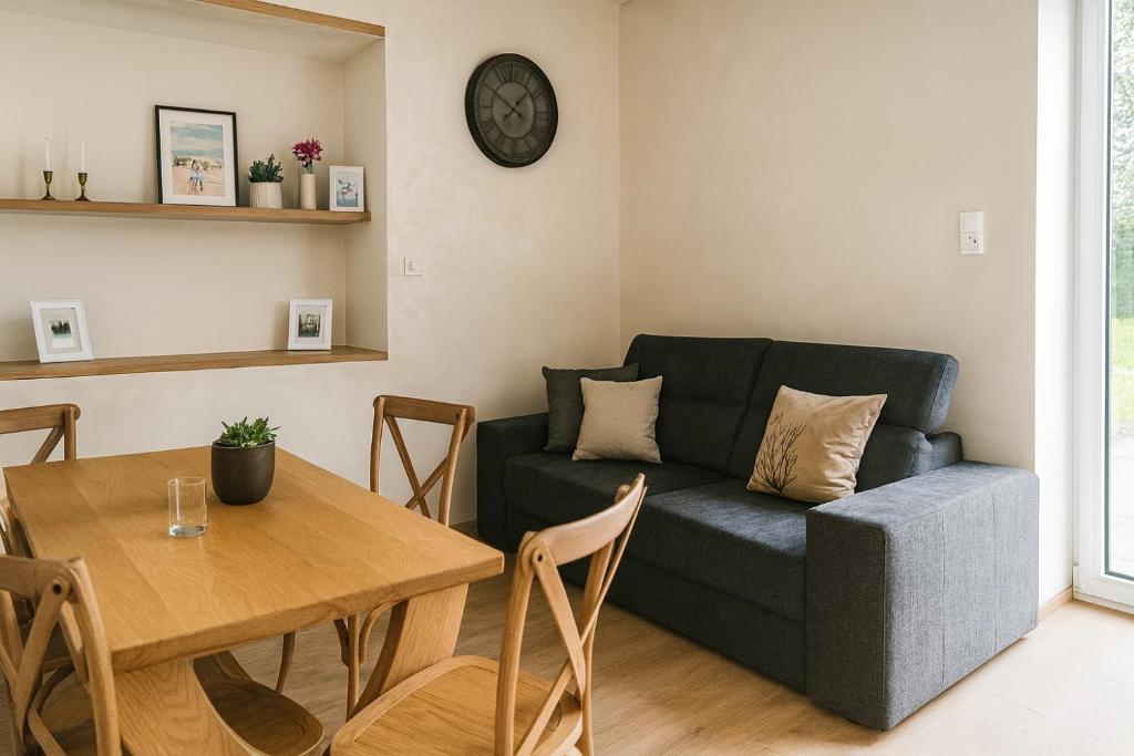 a living room with a couch and a table at Pieńki i Towarzystwo 6 niezależnych apartamentów 3 min od Suntago in Wręcza