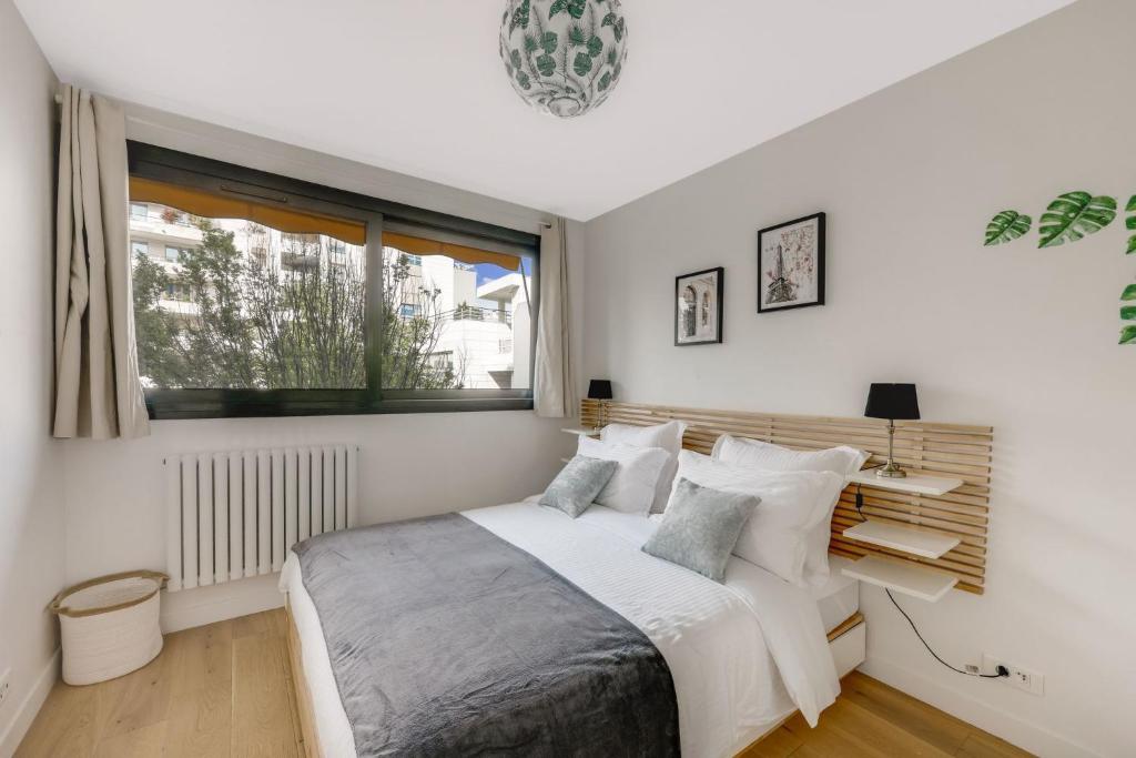 a white bedroom with a bed and a window at Espace Champerret - 1 Bedroom 4 people in Levallois-Perret