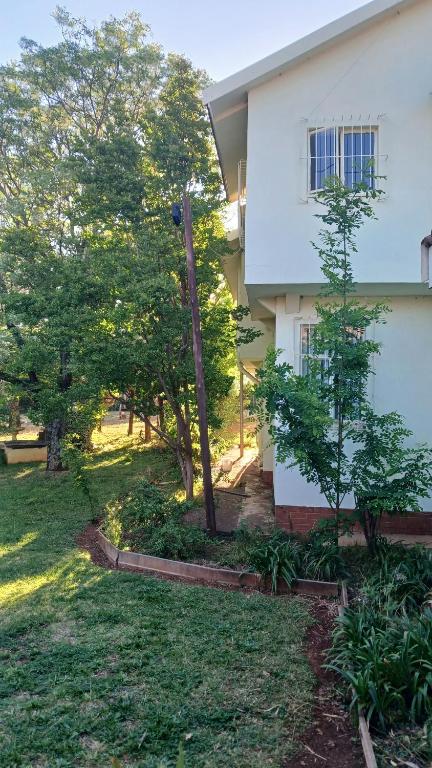 una casa con árboles frente a un patio en EL Golfview, en De Deur