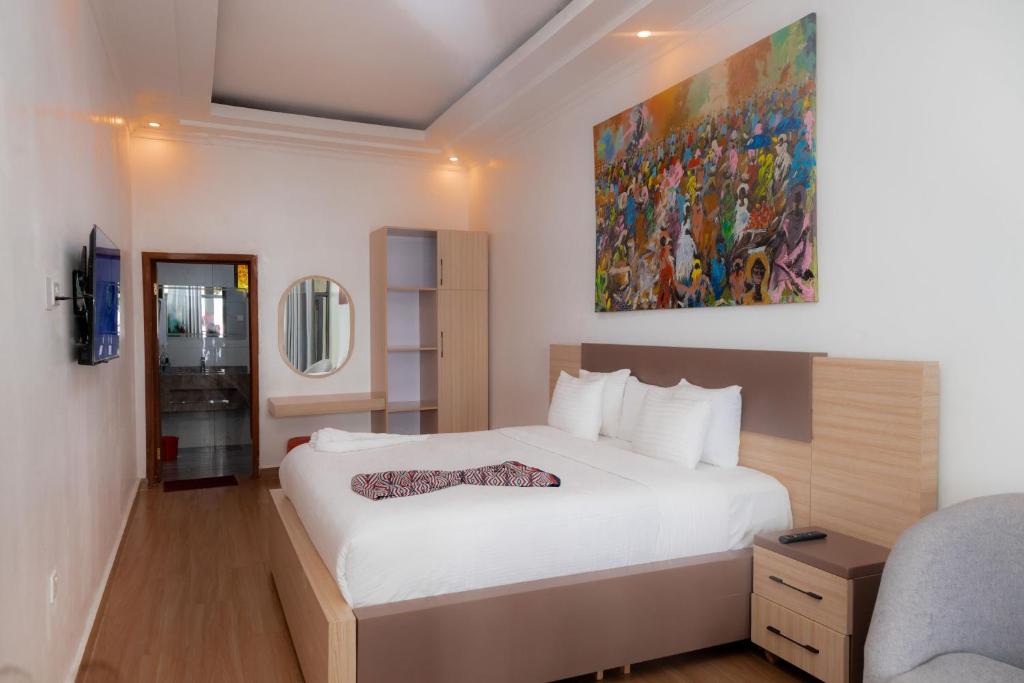 una camera da letto con un letto grande e un dipinto sul muro di Ruhondo Beach Resort a Ruhengeri