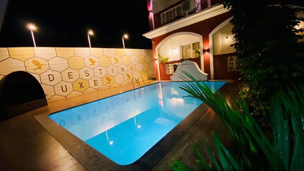 una piscina frente a una casa por la noche en URA Beach Calangute Goa, en Calangute