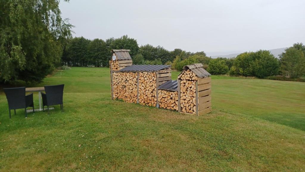 a building made out of fire wood in a field at Holiday Home Lumassote in Trois-Ponts