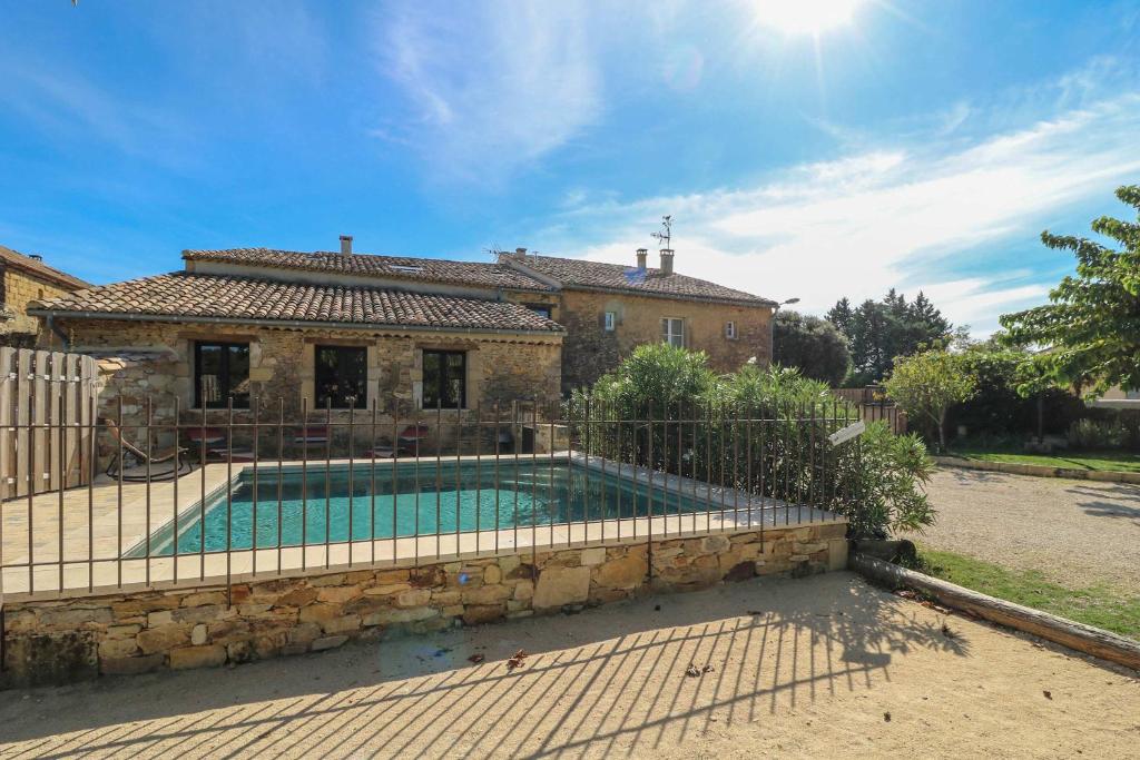 une maison avec une piscine devant une maison dans l'établissement Authentic Country House with pool near Uzes, à Fontarèches