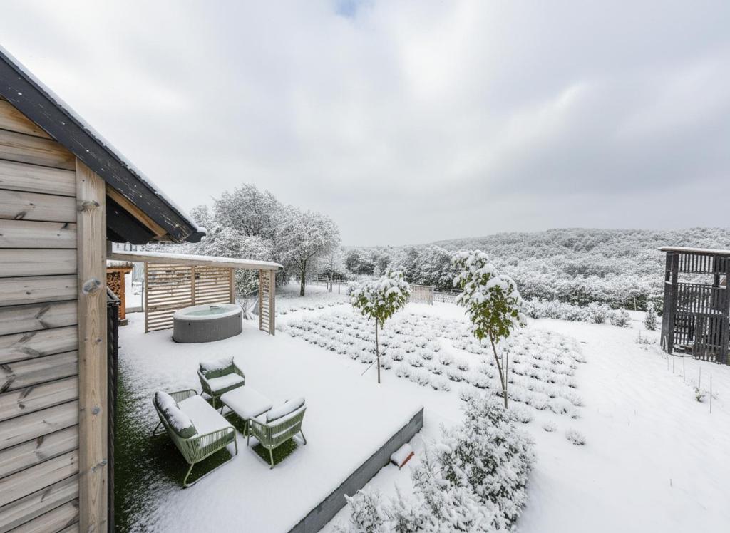 een met sneeuw bedekte patio met stoelen en een tafel bij WOWcabin - Lovas in Lovas