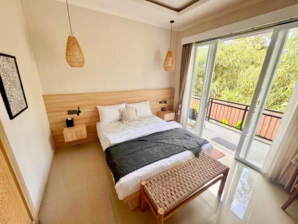 a bedroom with a bed and a large window at Villa Lulu - Uluwatu Nusa Dua in Ungasan