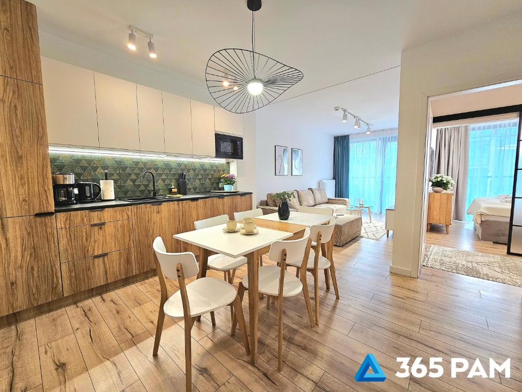 a kitchen and living room with a table and chairs at 365PAM - Apartament Leaf 6-osobowy in Ustronie Morskie