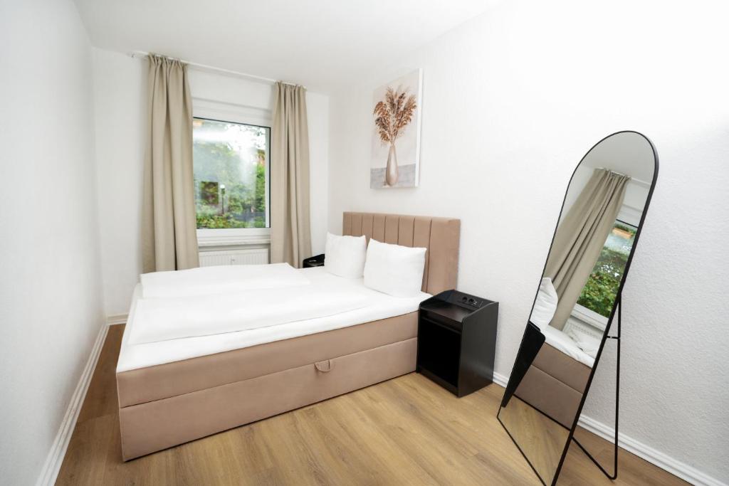 a small bedroom with a bed and a mirror at SHIN APARTMENTS in Essen
