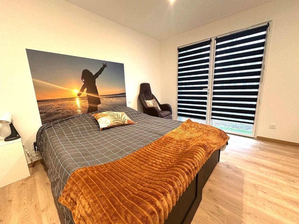 une chambre avec un lit avec une photo d'une personne dans l'établissement Refuge des voyageurs - studio neuf - Ancrage indépendant Rez de jardin, à Plouédern