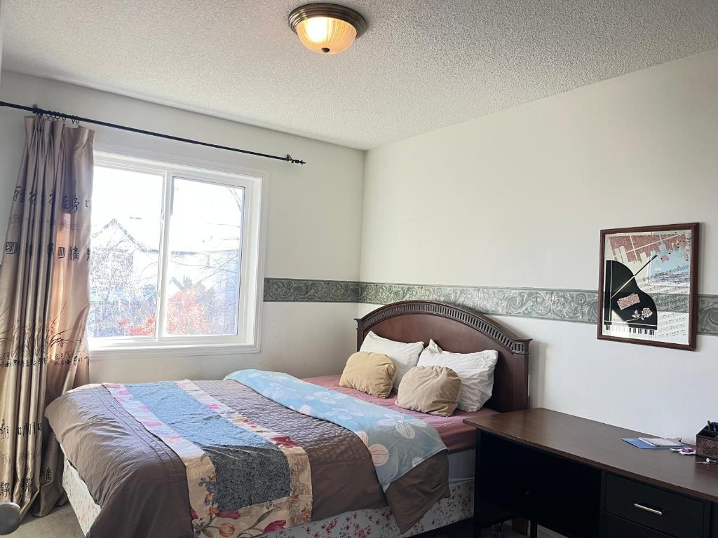 a bedroom with a bed with a desk and a window at Hidden valley treehouse home! in Calgary