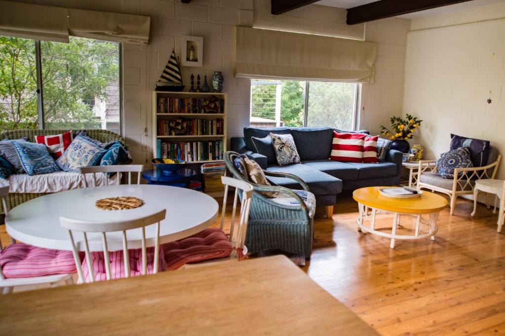 un salon avec un canapé et une table dans l'établissement Kywong Beach Cottage - cosy beach escape, à Bawley Point