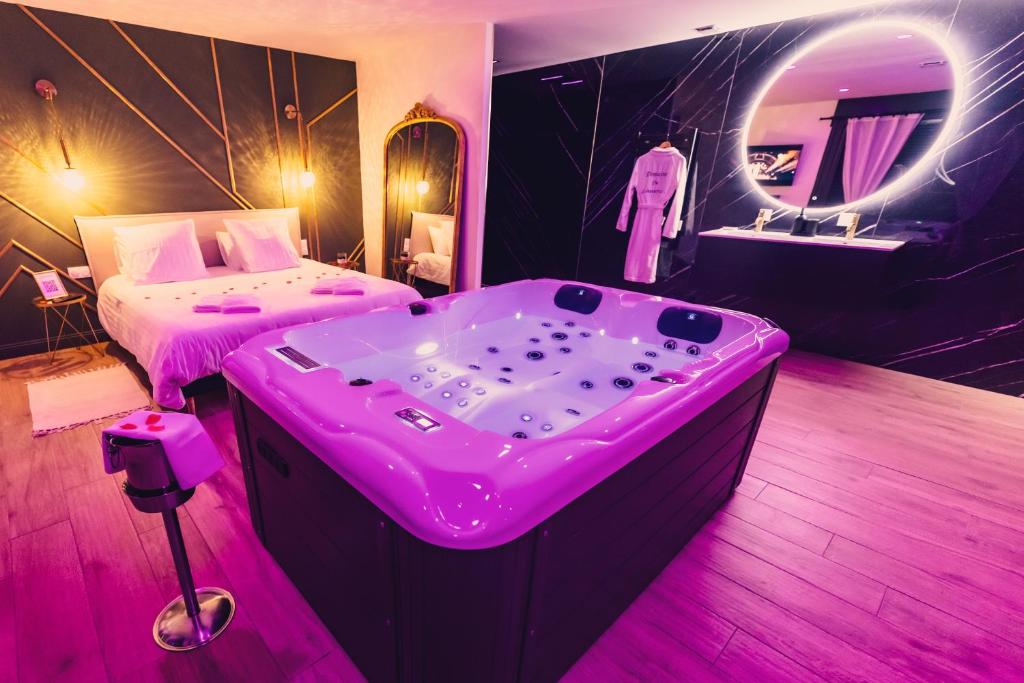 DoigniesLe Domaine de Louverval Suite & Spa的房间里有浴缸、床和镜子。