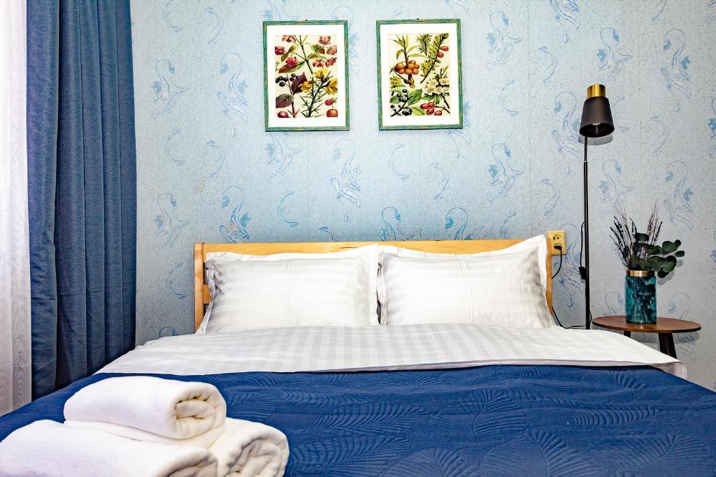 ein Schlafzimmer mit einem Bett mit zwei Bildern an der Wand in der Unterkunft 501 Чистая и уютная квартира в хорошем районе in Qapschaghai