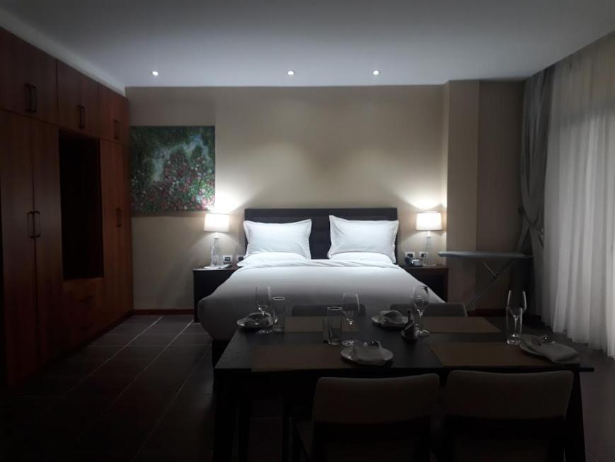 une chambre d'hôtel avec un lit, deux tables et des chaises dans l'établissement Yatu International Hotel, à Dirē Kʼalu