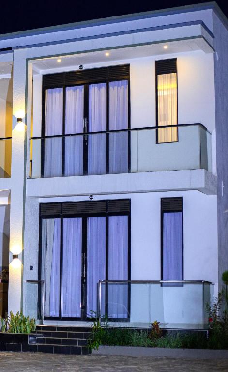 a white house with large windows at Serene 1bed, 1bath studio Apartment in Mbarara