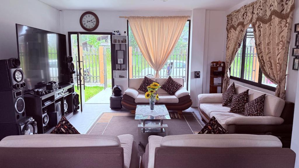 a living room with couches and a clock on the wall at Habitación doble # 3 in Macas