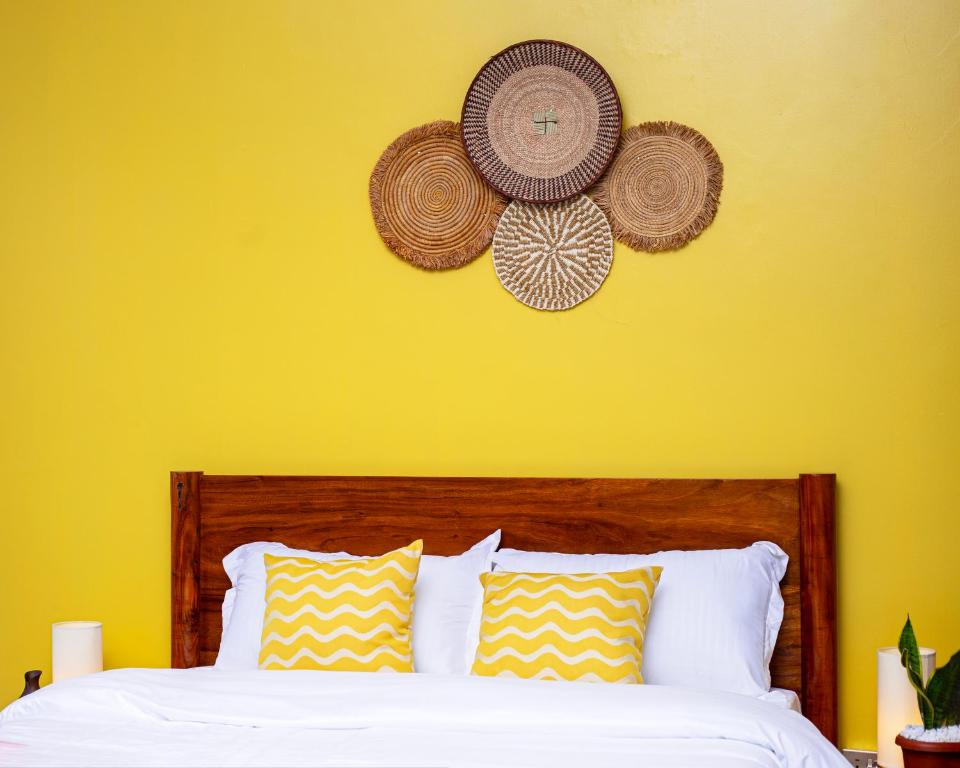a bedroom with a bed with a yellow wall at Serene 1bed, 1bath studio Apartment in Mbarara
