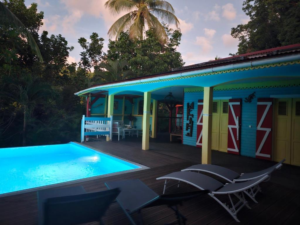 a house with a swimming pool next to a deck at KANOUAN in Deshaies