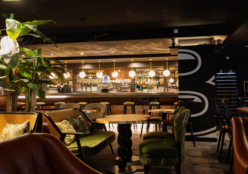 ein Restaurant mit Tischen und Stühlen und eine Bar in der Unterkunft Novotel Metz Centre in Metz